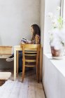 Жінка читає книгу в кафе — стокове фото