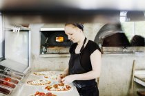 Female chef making pizza — Stock Photo