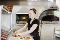 Female chef making pizza — Stock Photo
