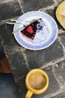 Fatia de bolo na placa com café na mesa — Fotografia de Stock