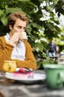 Homem bebendo café com bolo — Fotografia de Stock