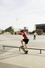 Mujer haciendo skate trick en parque - foto de stock