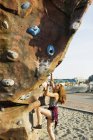 Adolescent fille escalade jusqu'à rocher artificiel — Photo de stock