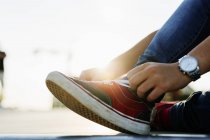 Дівчина-підліток зв'язує взуття мереживом — стокове фото