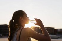 Woman drinking water at skate park — Stock Photo