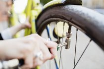 Женщина надувает колесо для велосипеда — стоковое фото
