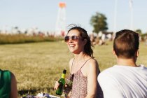 Frau hält Bierflasche bei Picknick — Stockfoto