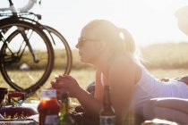 Frau liegt mit Essen und Trinken auf Feld — Stockfoto