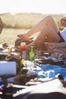 Женщина с едой и напитками на пикнике — стоковое фото