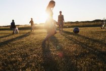 Друзі грають у футбол на полі — стокове фото