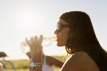 Woman drinking water from bottle — Stock Photo