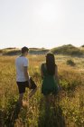 Couple walking on grassy field — Stock Photo