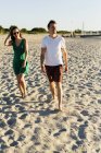 Пара прогулок по песку на пляже — стоковое фото