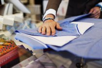Sales clerk folding t-shirt — Stock Photo