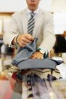 Verkäuferin faltet Hemd — Stockfoto