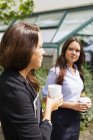 Geschäftsfrauen halten Kaffee — Stockfoto