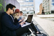 Freelancers que usan laptops en la ciudad - foto de stock