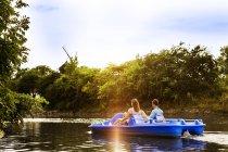 Друзья катаются на лодке по реке — стоковое фото