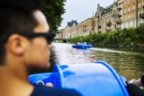 Mann tritt Boot auf Fluss in der Stadt — Stockfoto