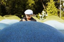 Boy leaning on artificial hill — Stock Photo