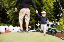Father and son playing on artificial hill — Stock Photo