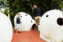 Father and son running by artificial igloos — Stock Photo