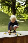 Хлопчик грає з іграшковими машинами в парку — стокове фото