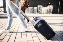 Estudiantes universitarios con equipaje caminando en la acera - foto de stock