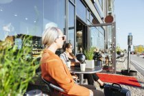 Empresárias olhando para longe enquanto sentadas no café — Fotografia de Stock