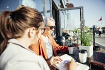 Бізнес-леді обговорює з колегою в кафе — стокове фото