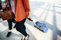 Mulheres de negócios com bagagem andando na rua — Fotografia de Stock