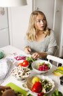 Woman looking away while cutting vegetables — Stock Photo