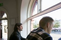 Männer blicken durch Fenster — Stockfoto