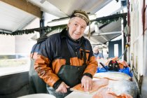 Fisherman filleting salmon in fishing industry — Stock Photo