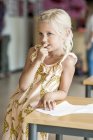 Thoughtful schoolgirl in classroom — Stock Photo
