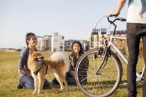 Pareja con perro y bicicleta - foto de stock