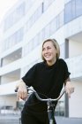 Student with bicycle against building — Stock Photo