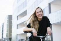 Estudante universitário inclinado na bicicleta — Fotografia de Stock