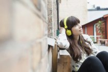 Жінка дивиться геть, слухаючи музику — стокове фото