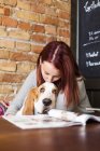 Young woman kissing Basset Hound — Stock Photo