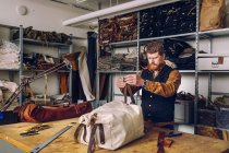 Мужчина на фабрике сумок — стоковое фото