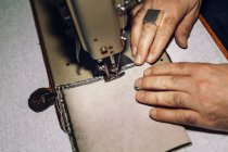 Male worker sewing bag — Stock Photo