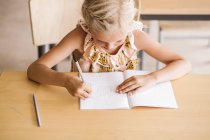 Girl writing in book — Stock Photo