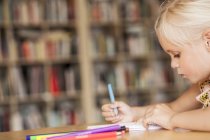 Menina para colorir na mesa em sala de aula — Fotografia de Stock