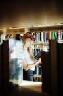 Joven estudiante universitario leyendo libro - foto de stock