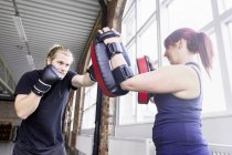 Man with female trainer practicing boxing — Stock Photo