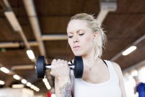 Young woman lifting dumbbell — Stock Photo