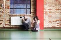 Homme et femme photographiant en studio de danse — Photo de stock