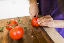 Chica rebanando tomates - foto de stock