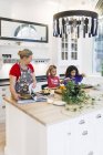 Mother and children cooking food in kitchen — Stock Photo